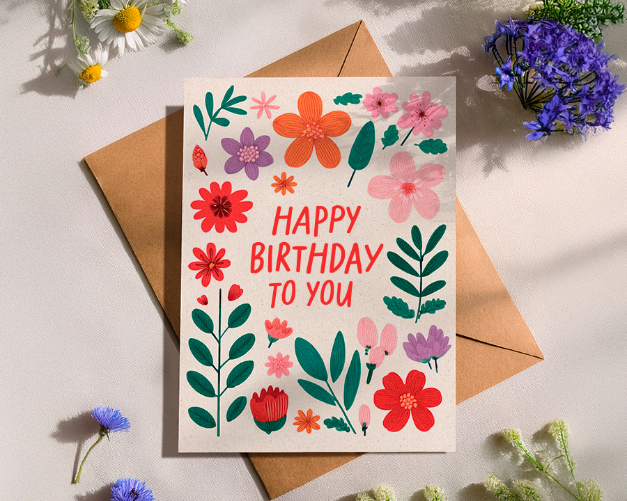 a birthday card with an assortment of flowers placed around it.