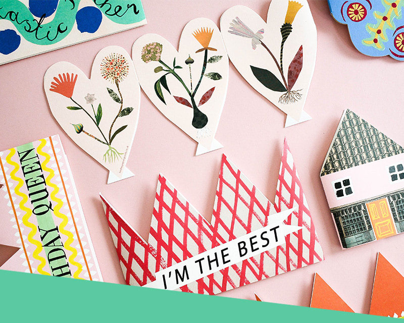 Selection of bespoke prints - custom-shaped greetings cards, crowns, and special ink finishes.